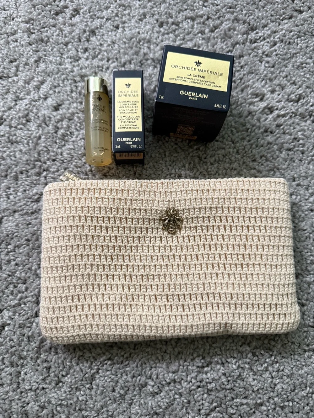 GUERLAIN gold and cream skincare set with woven clutch